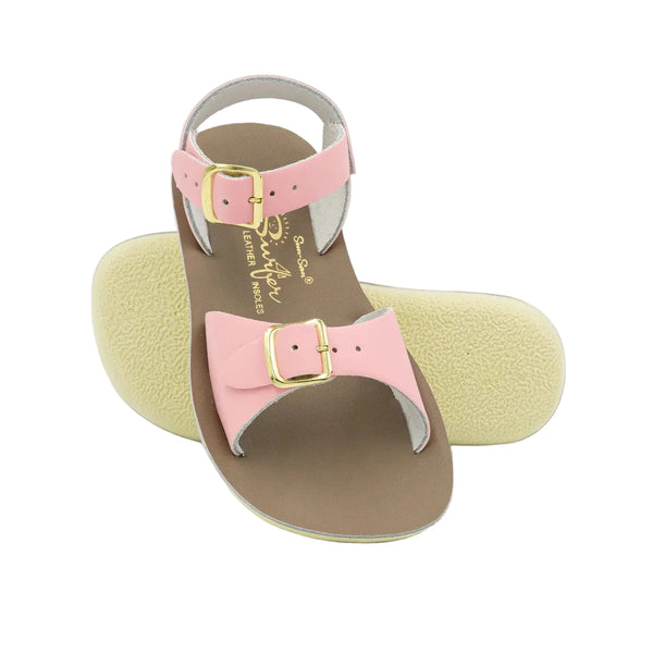 Sun San pink sandal with bow and gold buckle on a white background