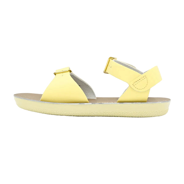 Sun San yellow sandal with a white sole on a light gray background